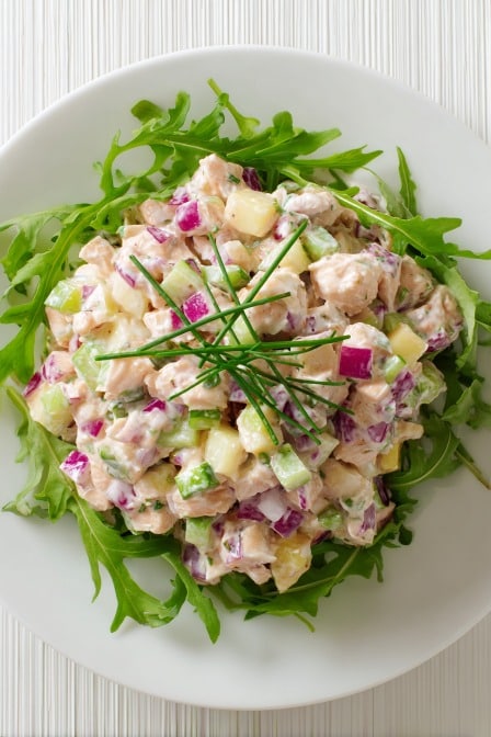 Diced chicken salad with crunchy celery, apples, and red onions on arugula, topped with fresh chives for extra flavor.