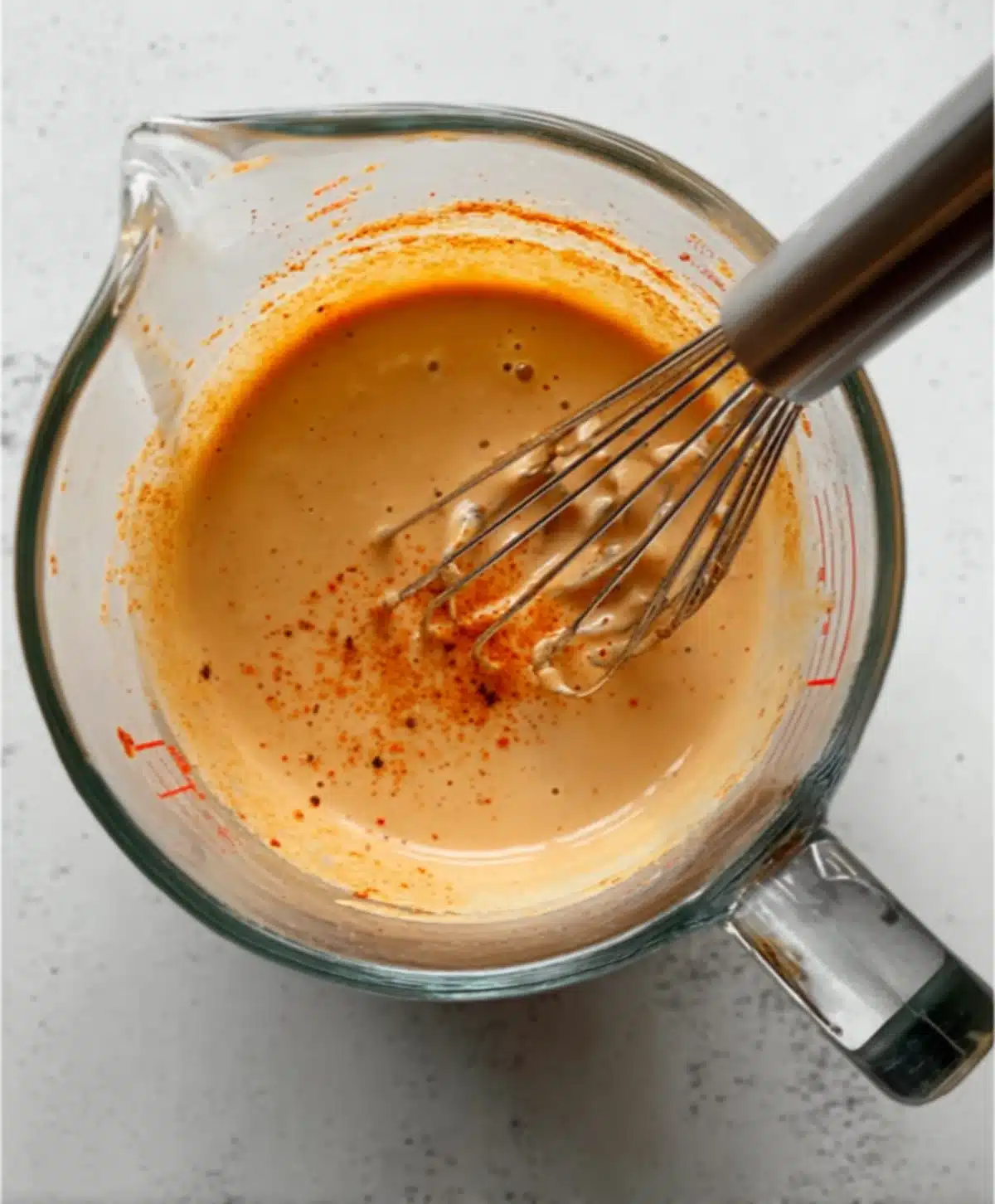 Creamy chipotle dressing being whisked in a glass bowl for flavorful Mexican chicken salad preparation