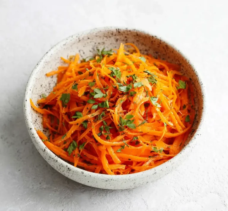 Carrot ribbons tossed with fresh mint in a ceramic bowl, ideal for Ray Peat’s raw carrot salad to support gut health