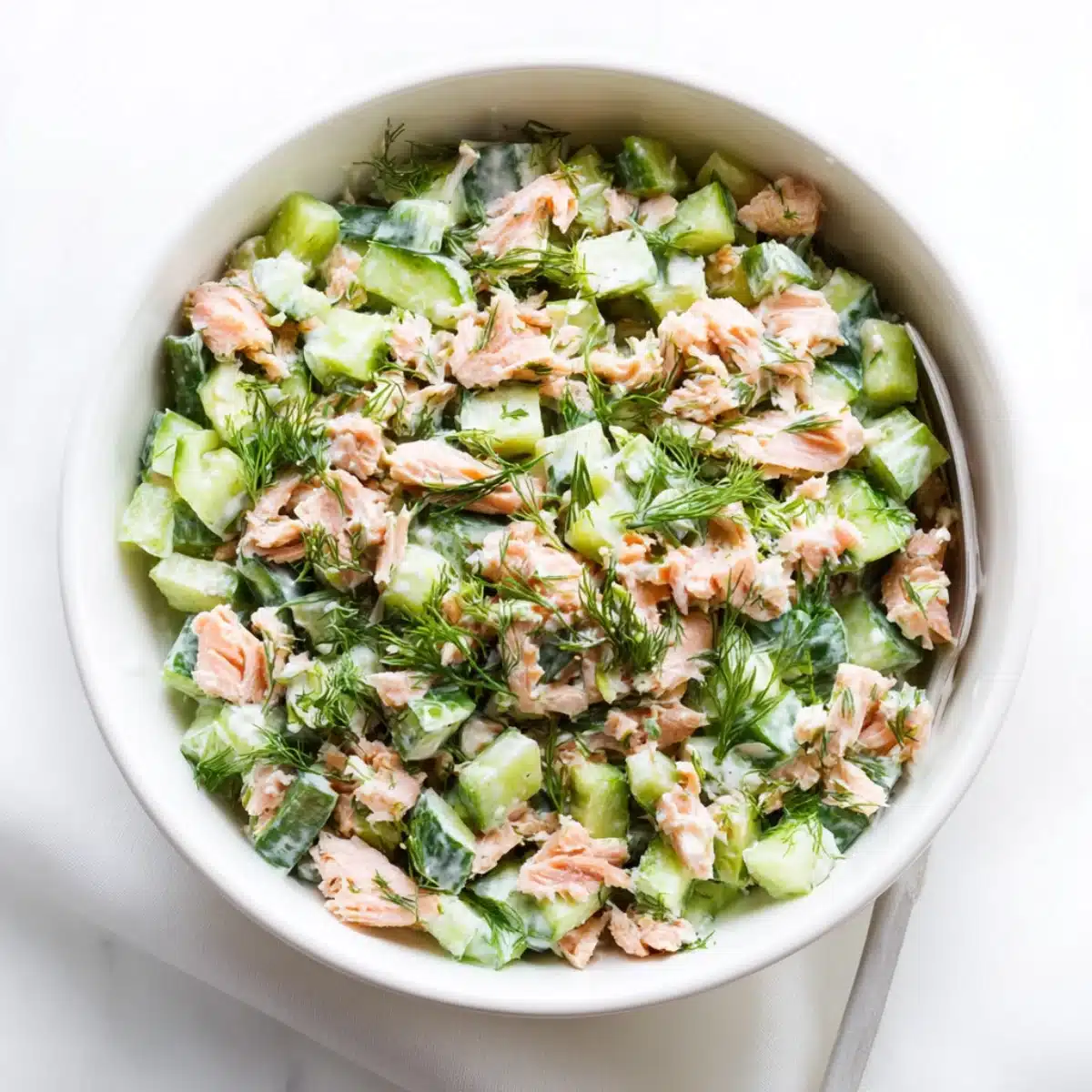 Fresh salmon cucumber salad with creamy dressing and dill, perfect for a light and healthy summer meal.