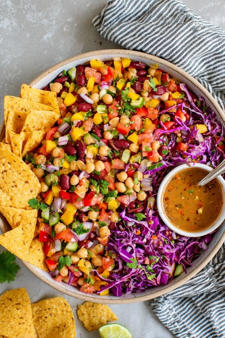 Southwest bean salad with chickpeas, cabbage, bell peppers, and dressing served with tortilla chips