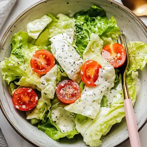 Miracle Salad with crisp romaine, cherry tomatoes, and creamy dressing, topped with cracked black pepper