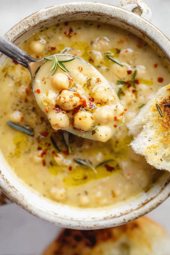 A close-up of Delicious Garlic Chickpea Soup in a rustic ceramic bowl