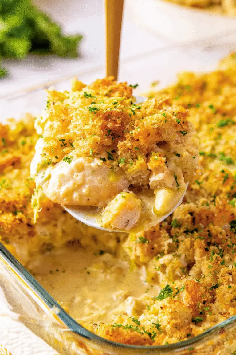 Chicken and Stuffing Casserole, close-up view, creamy golden casserole being lifted with a serving spatula from a glass baking dish